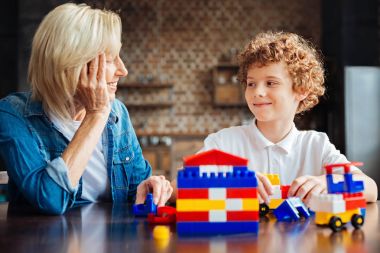 Akıllı kıvırcık saçlı çocuk büyükanne ile vakit