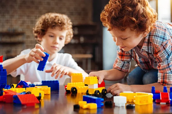 Mignon gingembre chevelu garçon construction voiture sur table — Photo