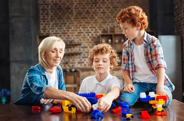 Çocuklar evde oynarken sevgi dolu büyükanne