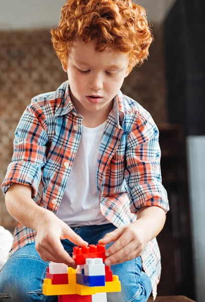 Menino concentrado brincando com blocos de construção — Fotografia de Stock