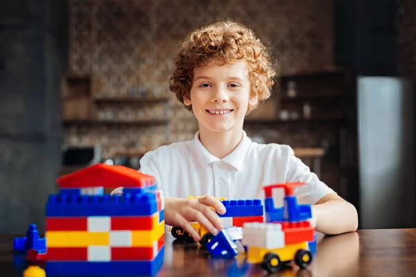 Fröhlicher Junge grinst breit beim Spielen zu Hause — Stockfoto