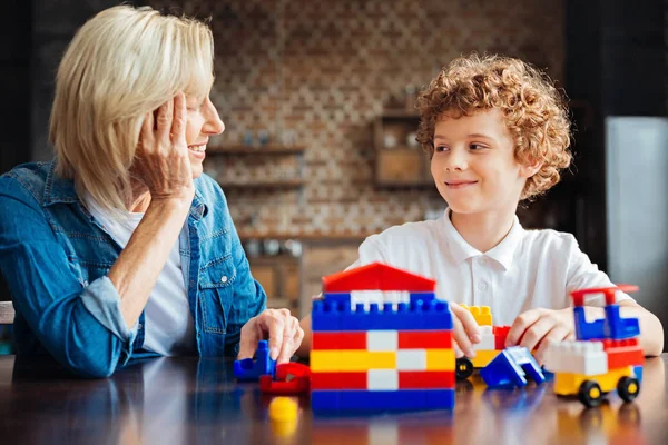 Akıllı kıvırcık saçlı çocuk büyükanne ile vakit