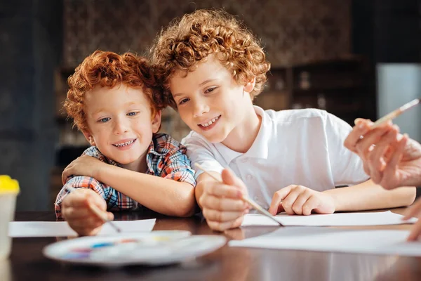 Szerető testvérek asztalnál együtt festés — Stock Fotó