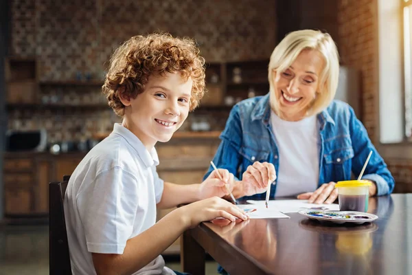 Emocionado niño de pelo rizado disfrutando de pasar tiempo con la abuela — Foto de Stock