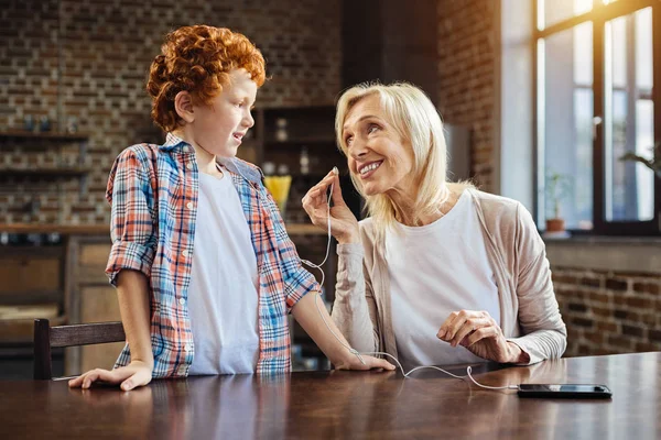 Liefdevolle oma haar kleinkind vragen voor het luisteren naar muziek samen — Stockfoto