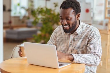 Mutlu adam kafede dizüstü bilgisayarda yeni app geliştirme