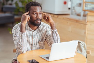 Yorgun adam kafede çalışırken tapınaklar Masaj