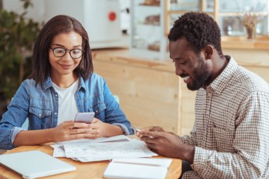 Genç meslektaşları kafede otururken metin mesajları gönderme