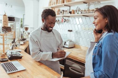 Telefonla yapılan sipariş aşağı koyarak barista gülümseyen