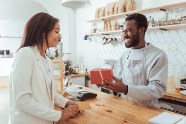Onun müşteri sipariş kutusuyla veren gülümseyen barista