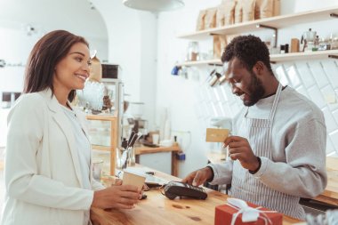 Ödeme işlemi gerçekleştirmeden barista gülümseyen