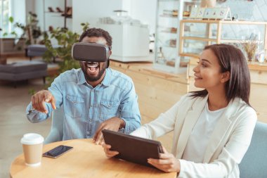 Heyecanlı adam kafede Vr kulaklık ile oynarken