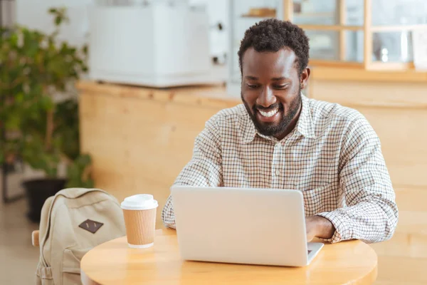 Kafede dizüstü bilgisayarda çalışma çekici genç adam