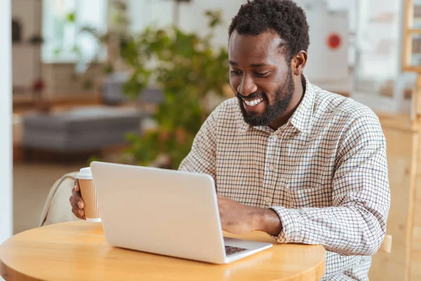 Mutlu adam kafede dizüstü bilgisayarda yeni app geliştirme