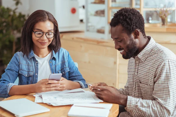Genç meslektaşları kafede otururken metin mesajları gönderme