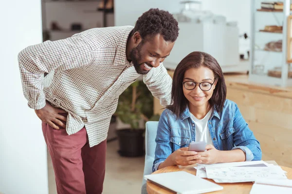 Vrolijke man kijken naar zijn collega's telefoon — Stockfoto