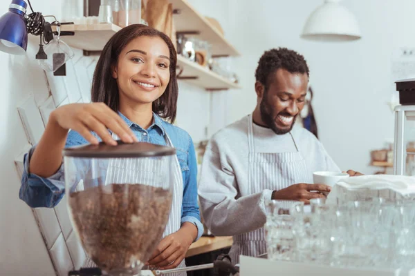 Nuevos baristas alegres entrenando su arte de hacer café — Foto de Stock