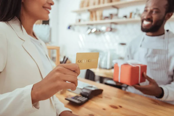 Feminino cliente cafetaria segurando um cartão de ouro — Fotografia de Stock