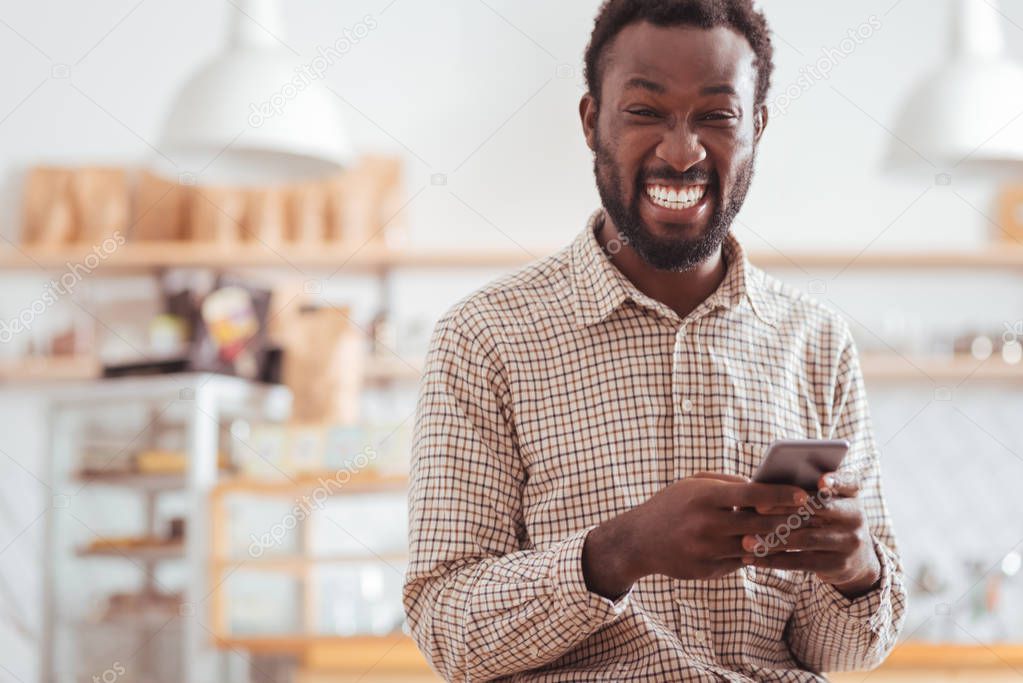 Overjoyed man laughing at his friends text messages