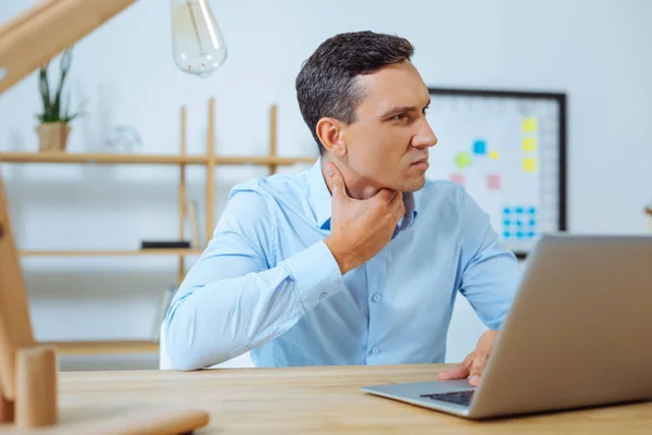 Hombre serio tocándose el cuello — Foto de Stock