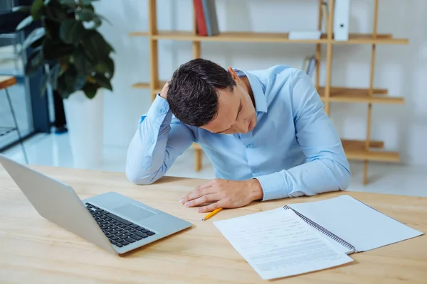 Disappointed man bowing head while working — Stock Photo, Image