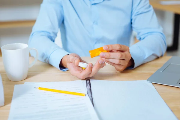 Primer plano del paquete naranja que estando en la mano masculina — Foto de Stock