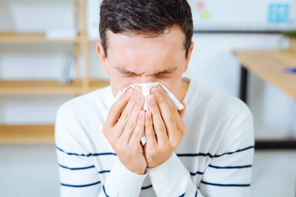 Portrait of sick worker that having running nose