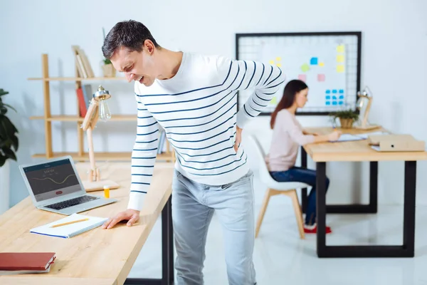 Anxious brunette man having pain in back — Stock Photo, Image