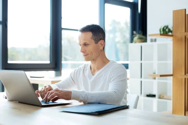 Knappe vrolijke zakenman te typen op het toetsenbord — Stockfoto