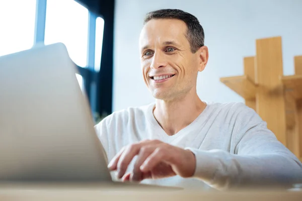 Fröhlich positiver Geschäftsmann mit Blick auf den Laptop-Bildschirm — Stockfoto