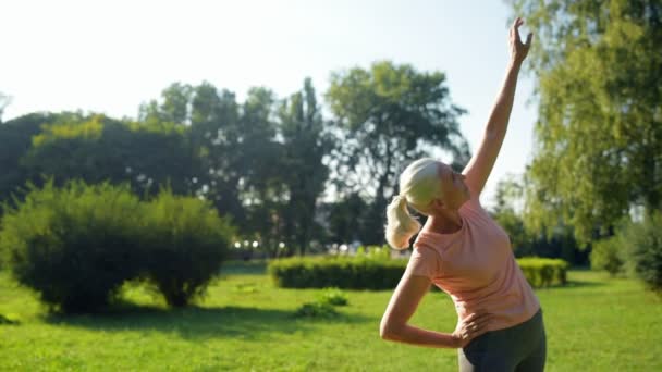 Женщина тонизирует мышцы в парке — стоковое видео