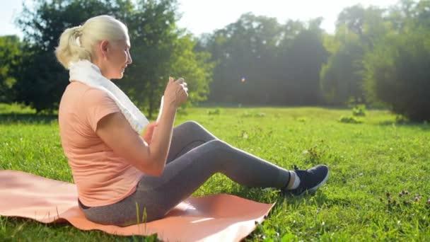 Mulher descansando no parque após exercícios matinais — Vídeo de Stock