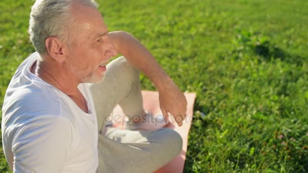 Muž odpočívá po sportovní cvičení v parku — Stock video