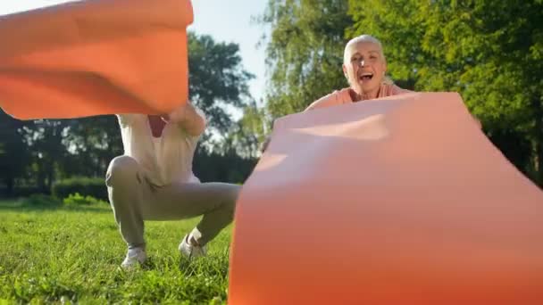 Couple déroulant leurs tapis d'exercice — Video