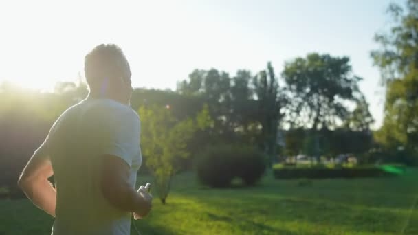 Sportlicher älterer Mann joggt im Park — Stockvideo