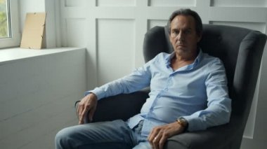 Orta yaşlı adam koltukta, dinlenme