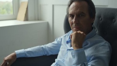 Çene altından elini tutarak orta yaşlı adam