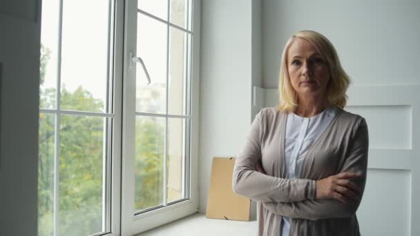 Calme femme d'âge moyen debout près de la fenêtre — Video