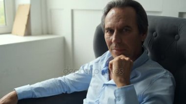 Çene altında bir el ile pozitif orta yaşlı adam
