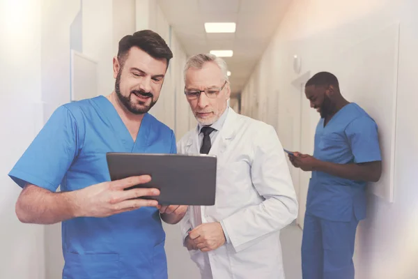 Positive delighted intern demonstrating his gadget — Stock Photo, Image