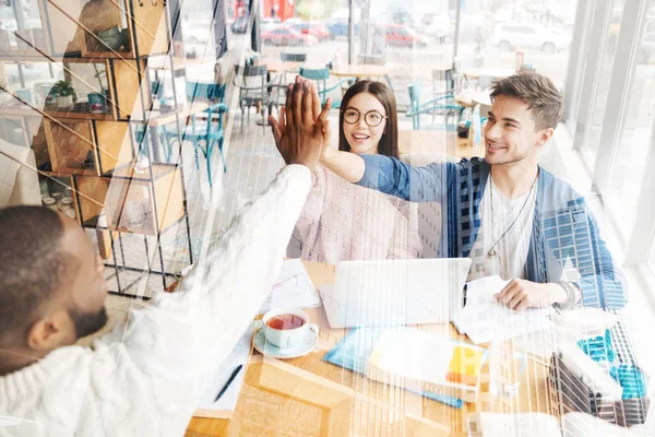 Çak bir beşlik veren gülümseyen iş arkadaşları