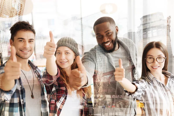 Cheerful colleagues raising thumbs up — Stock Photo, Image