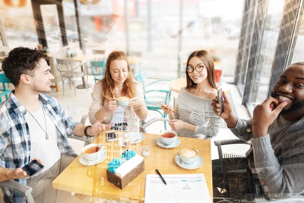 Positiva vänner sitter vid bordet — Stockfoto