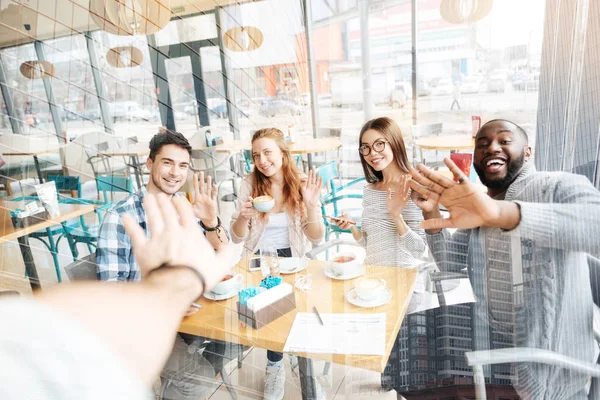 Pleased friends giving five at the table