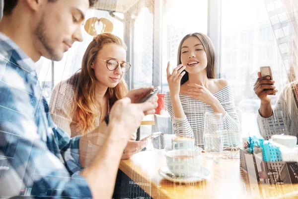 Amigos alegres usando teléfonos móviles — Foto de Stock