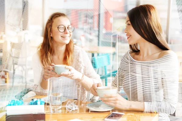 Meninas alegres bebendo café juntos — Fotografia de Stock