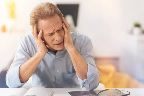 Müder reifer Mann sitzt im Büro — Stockfoto