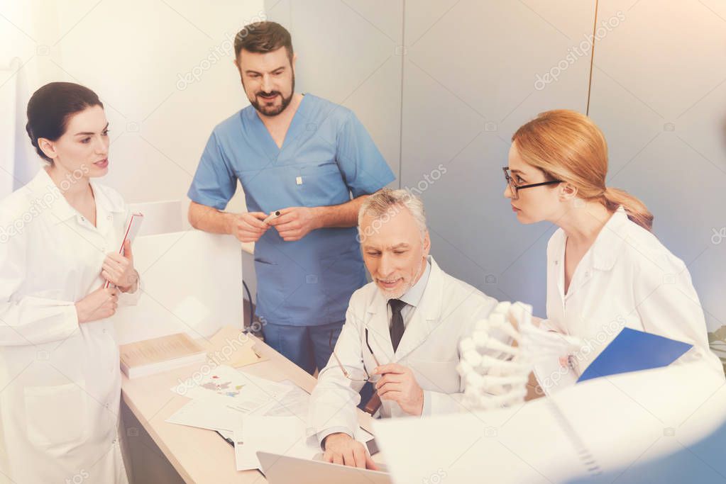 Delighted professor sitting in center of the table