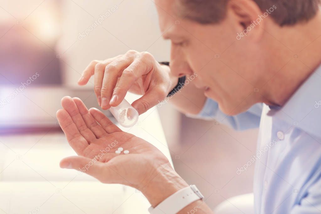Close up of a sick man taking pills