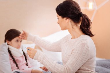 Sevgi dolu bir anne hasta kızı sıcaklığını kontrol